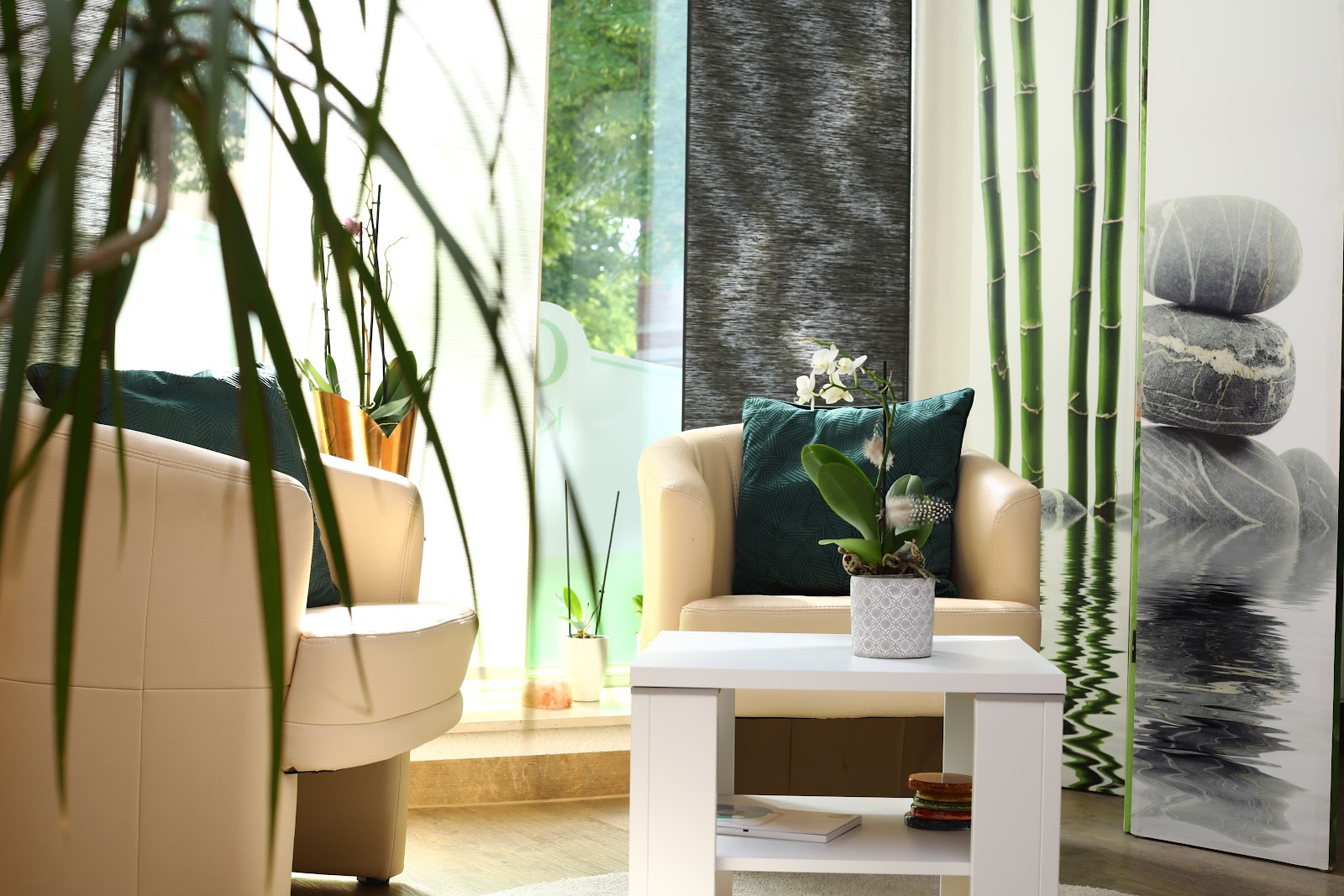 Loungebereich mit Sesseln und Bambus-Wandbild bei CosVital