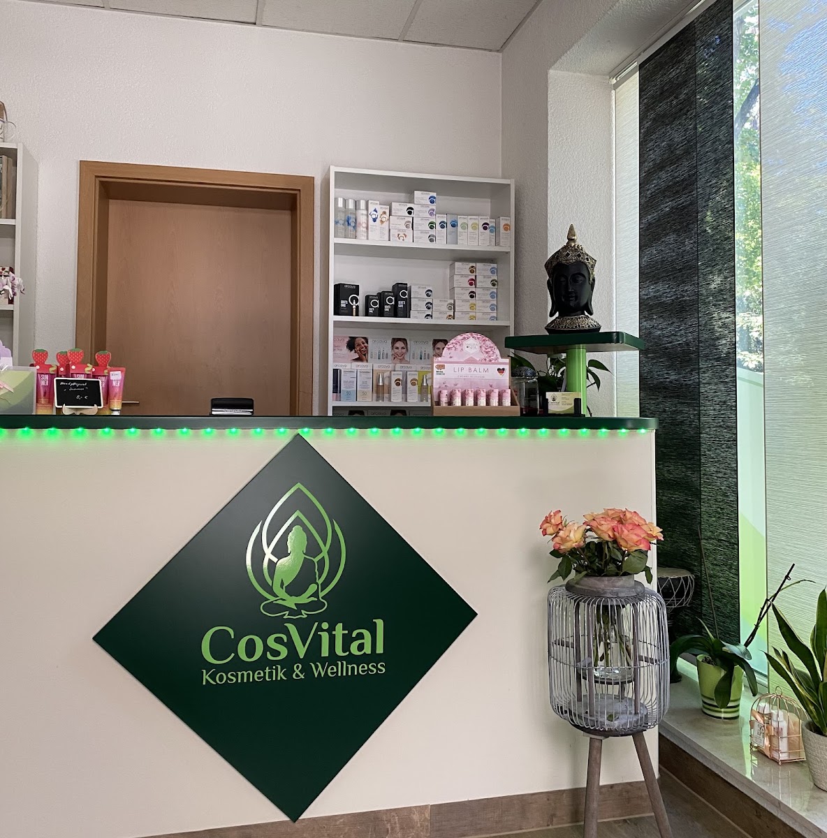 Empfangstresen von CosVital mit dem grünen CosVital-Logo