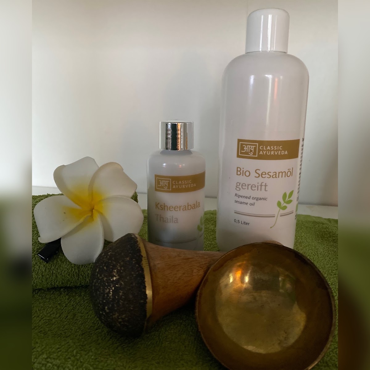 Ayurveda-Öle und Massagewerkzeug mit Frangipani-Blüte